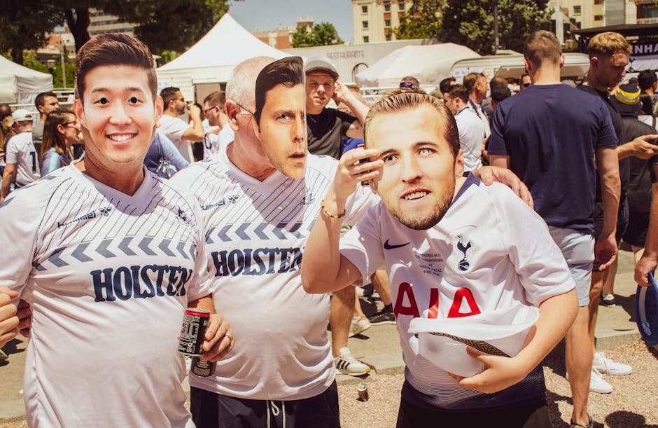 Group of soccer fans donning team jerseys and masks at an outdoor event in Madrid.