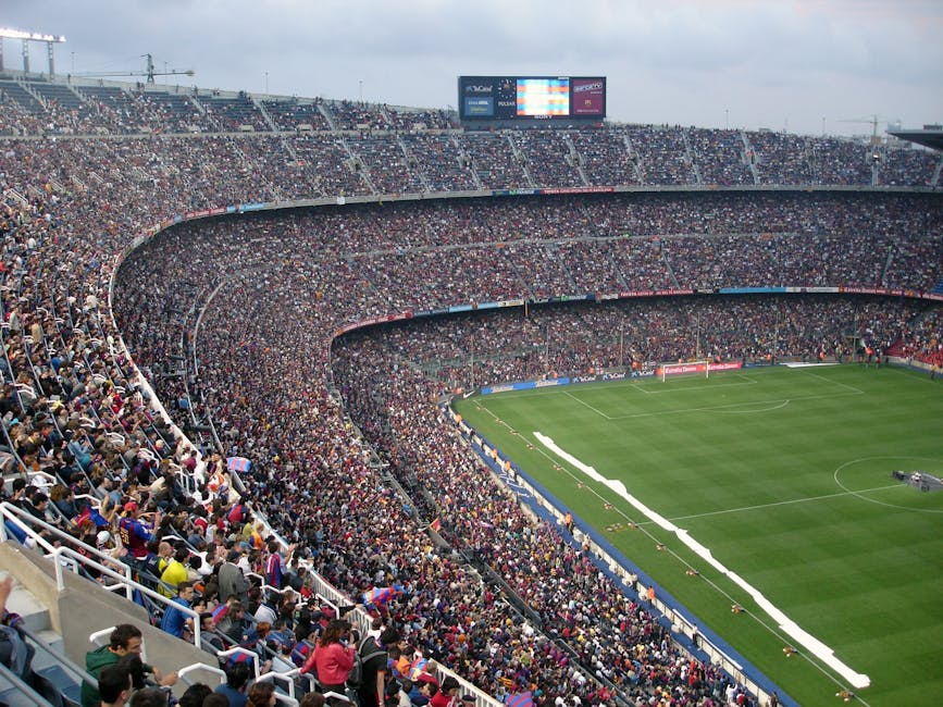 A packed stadium with enthusiastic fans watching an exciting soccer match.