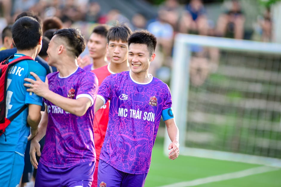 Joyful youth football team on field celebrating their win in Hà Nội.