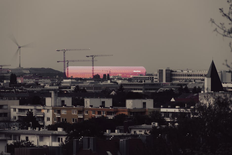 Captivating twilight view of Munich skyline with the famed Allianz Arena beautifully illuminated in pink.