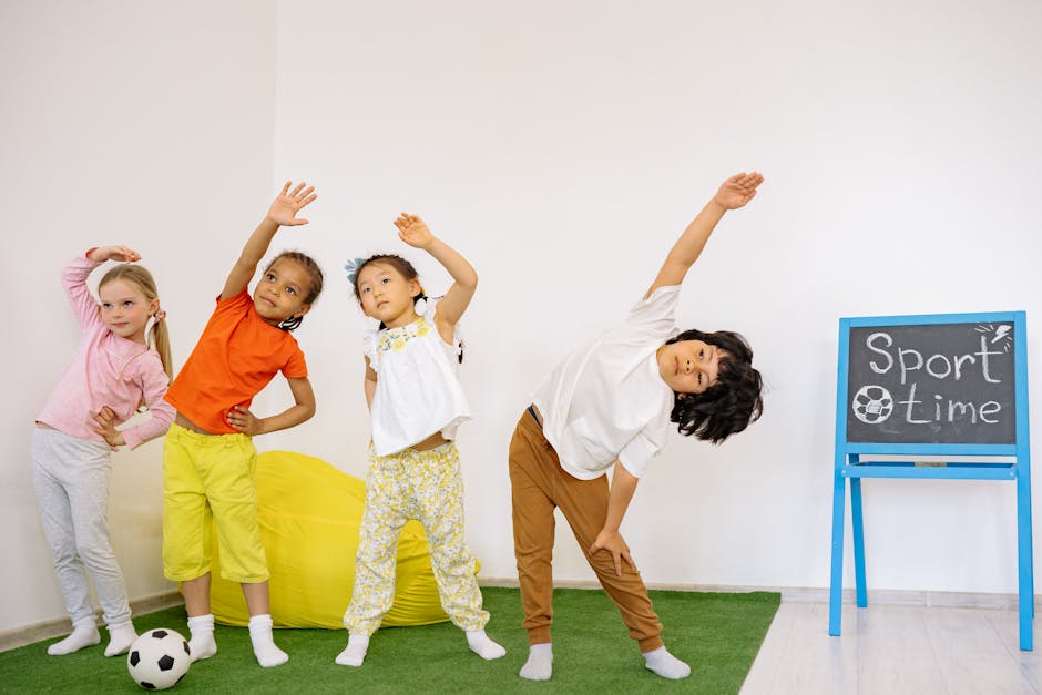 Joyful children stretching during indoor sport time in a classroom.