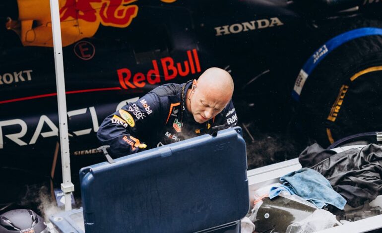 Intense moment as a Formula 1 pit crew member works on a Red Bull racing car during a pit stop.