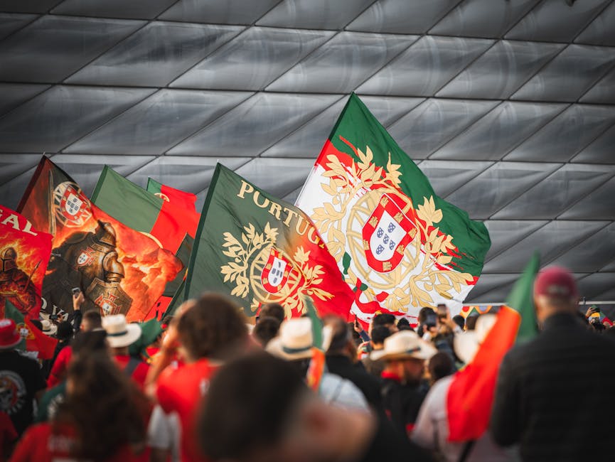Crowd of Portuguese fans waving flags at Allianz Arena in Munich during a football event.