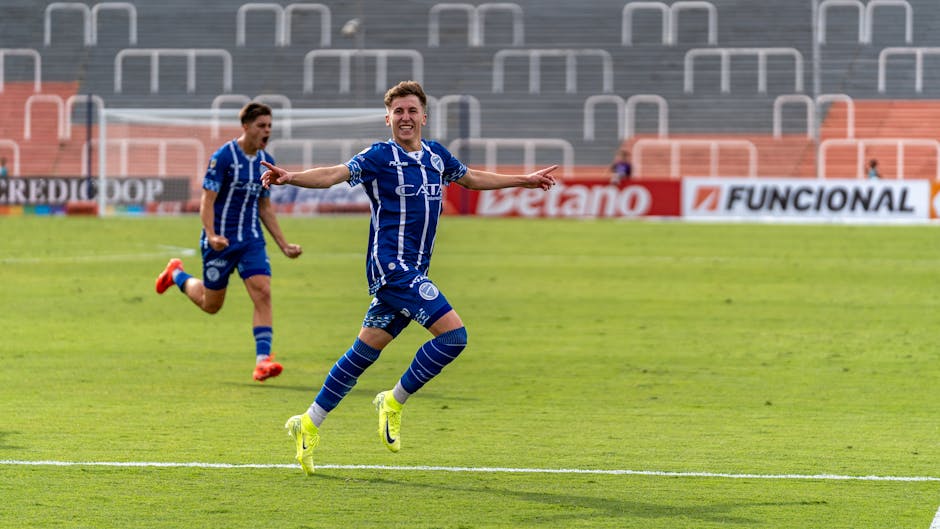 Excited soccer players celebrate a goal on the field during a match.