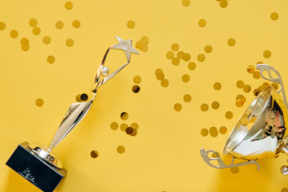 Golden trophy with celebratory confetti on a vibrant yellow background.