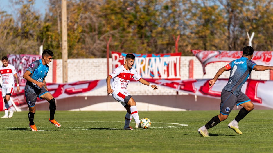 Action-packed football match with players in full motion on a sunny day.