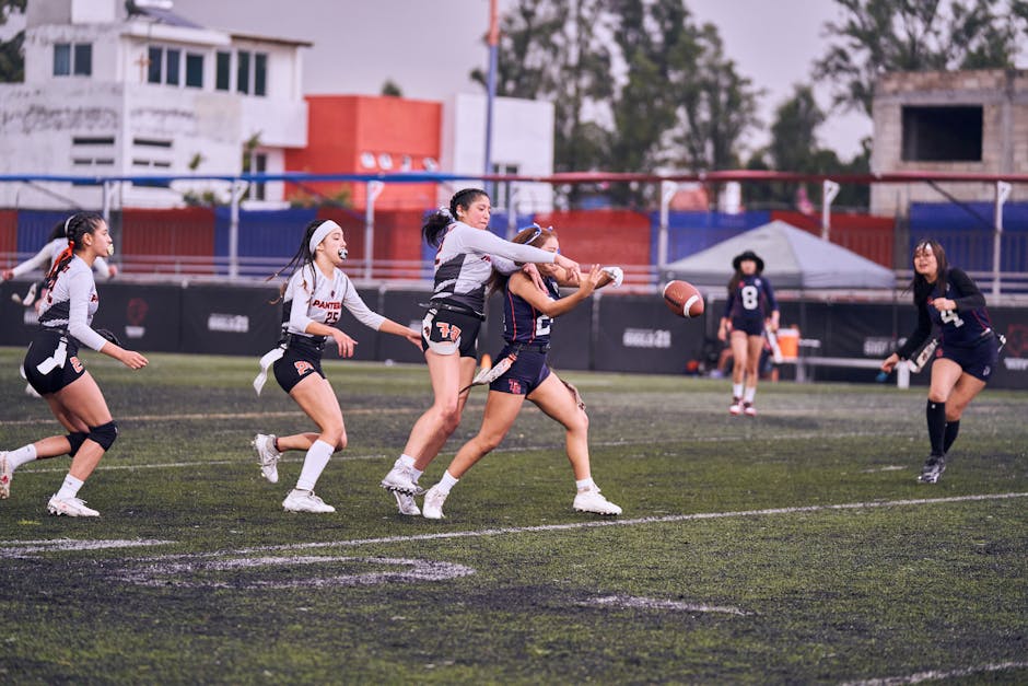 Intense women's flag football game with players in motion on outdoor field.