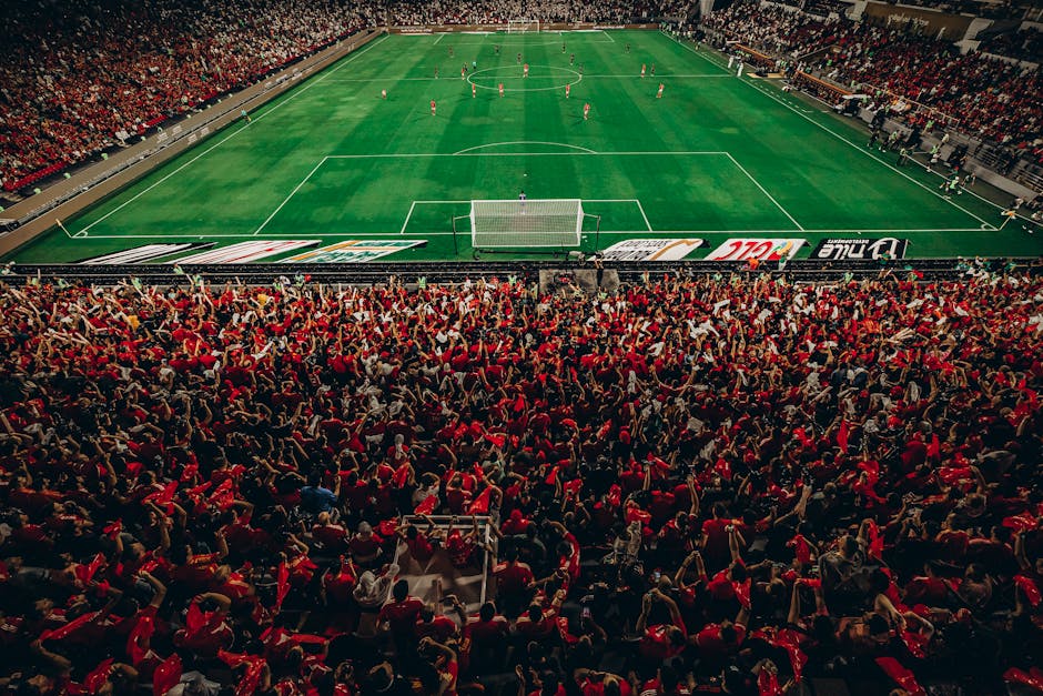 Aerial shot of a lively football match with enthusiastic fans in a packed stadium.