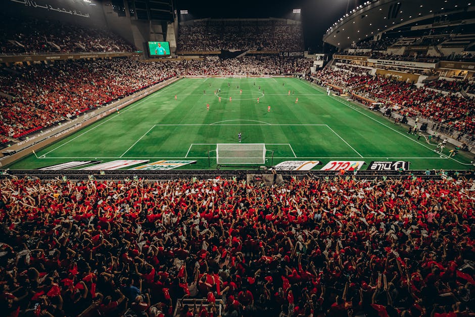 A thrilling nighttime football match with a vibrant crowd in Abu Dhabi stadium.