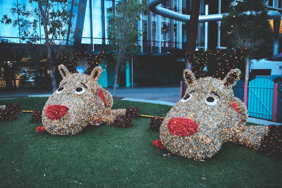Bright reindeer light sculptures on grass, perfect for holiday decor.