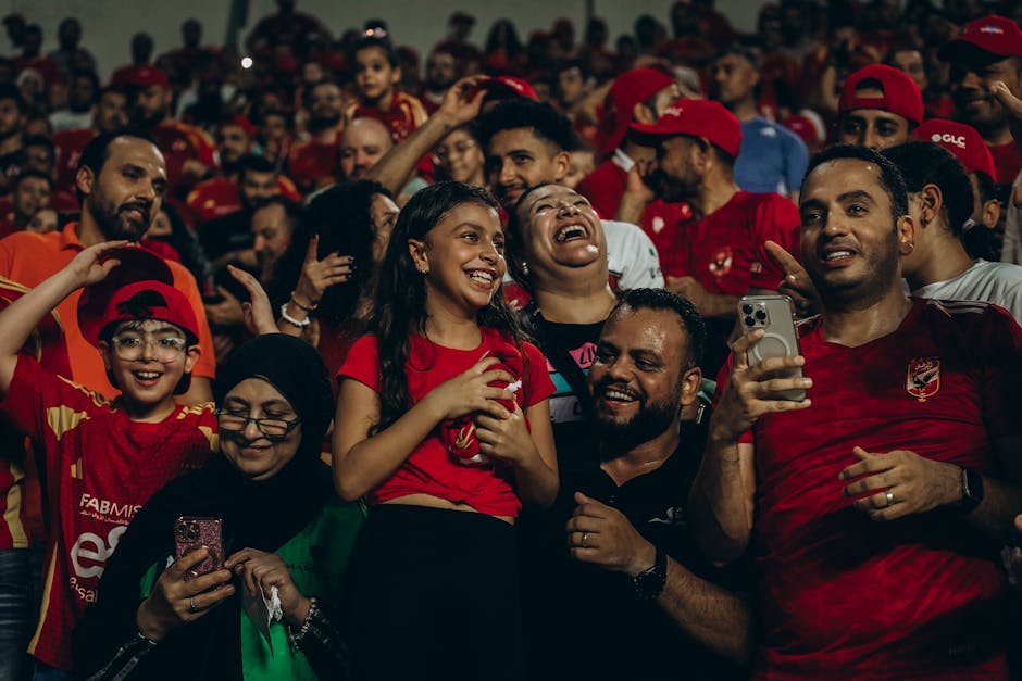Excited fans cheering during a live football match, capturing the joy and thrill of the sports event.