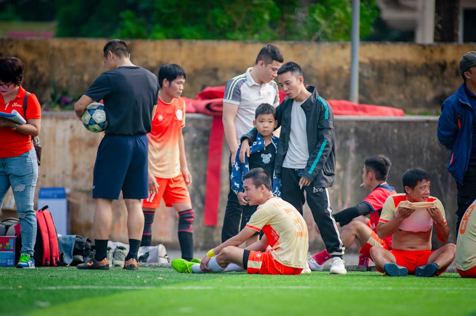 Soccer players resting and discussing strategy during a break in Hanoi, Vietnam.