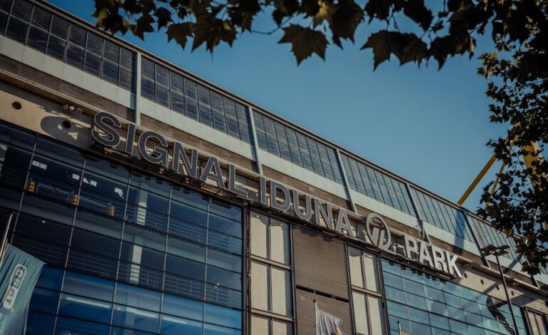 Exterior view of Signal Iduna Park stadium in Dortmund, Germany under clear blue sky.