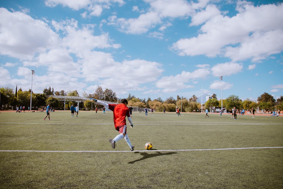 A lively outdoor soccer match with players in action on a sunny day.