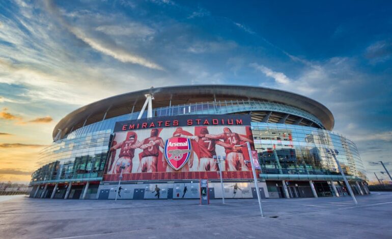 View of Emirates Stadium, home of Arsenal FC in London, showcasing modern architecture under a vibrant sky.