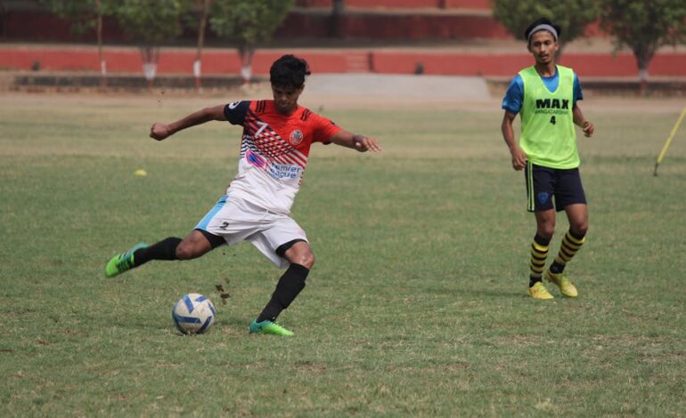 Two soccer players in action on the field during a match, showcasing athleticism.