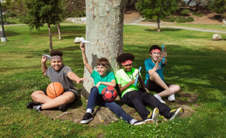 A group of kids having fun with balls and paper planes in a sunny park setting.