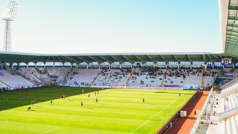 A thrilling soccer match at Kazim Karabekir Stadium in Erzurum, Turkey, under a clear sky.