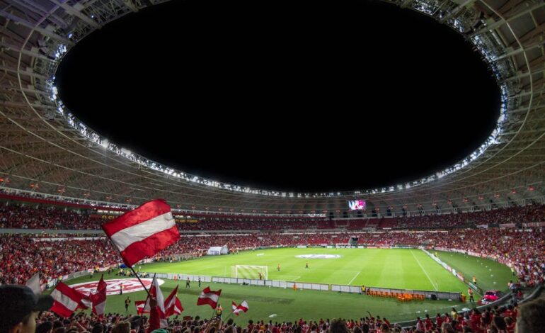 Exciting soccer match with enthusiastic fans in a packed stadium under bright lights.
