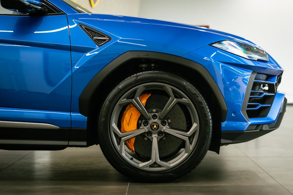 Detailed close-up of a blue Lamborghini sports car showcasing the wheel and design.