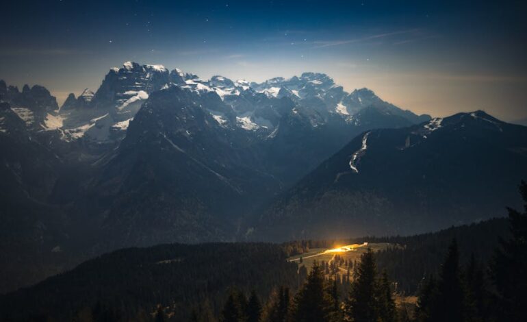 Stunning astrophotography showcasing the Milky Way over snow-capped Italian Alps at night.