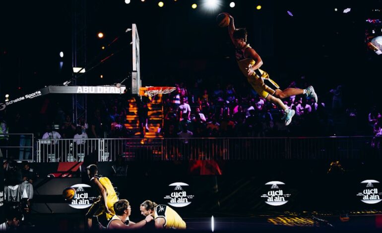 Basketball player performing an impressive slam dunk during an Abu Dhabi sports event.