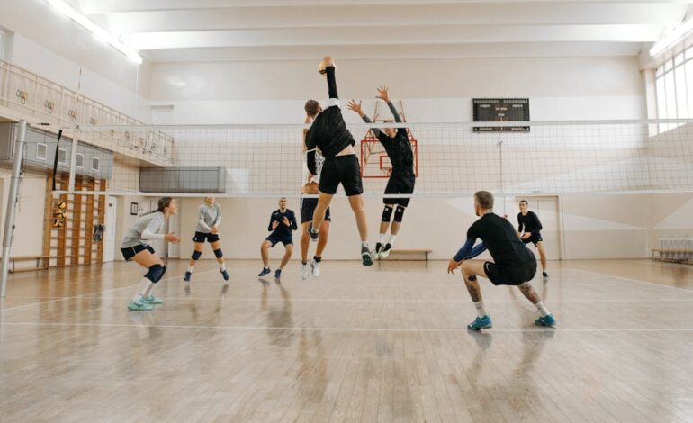 Men and women engaged in a competitive indoor volleyball match, showcasing teamwork and athleticism.