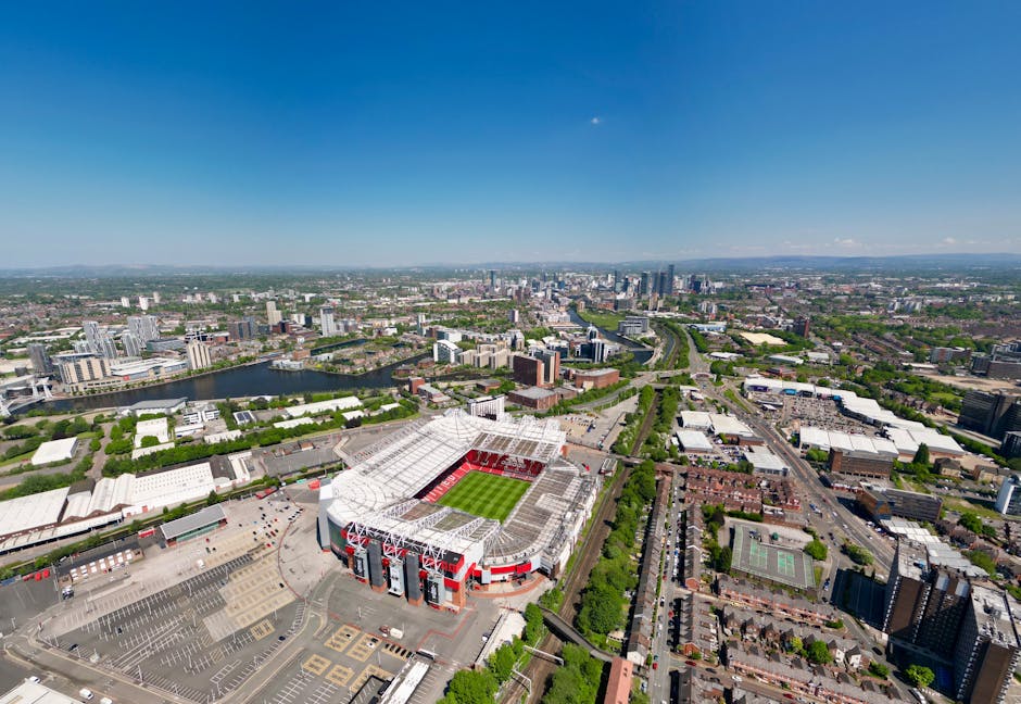 Stunning aerial view of a modern stadium in a vibrant urban landscape on a sunny day.