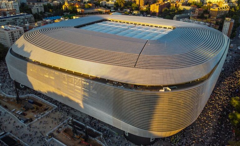 Aerial shot of Santiago Bernabéu Stadium in Madrid during sunset showcasing its modern architecture.