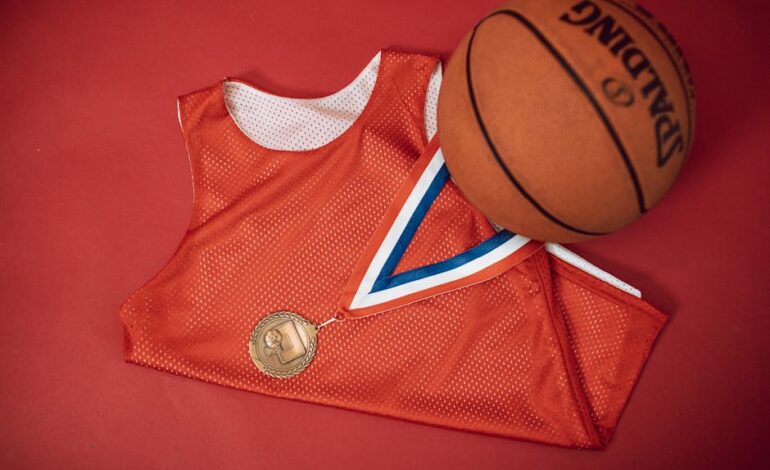A red basketball jersey paired with a medal and Spalding basketball on a red backdrop.