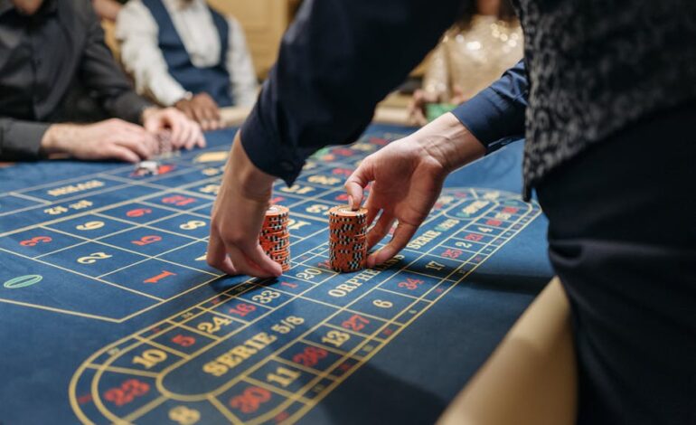 Close-up of players placing poker chips on a blue roulette table in a casino setting.