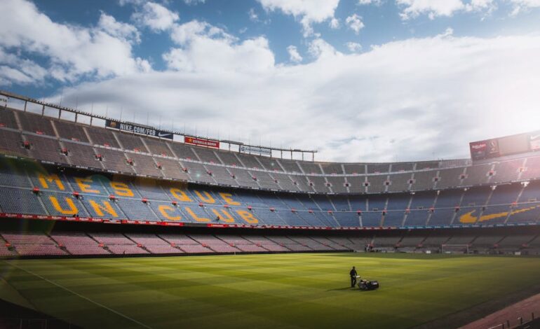 A vibrant football stadium with a well-maintained grass field under a bright sky, showcasing its iconic architecture.