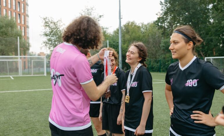 A women's football team receiving medals on the field, celebrating their victory.
