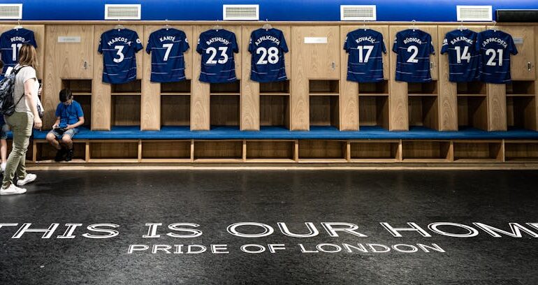 Locker room at Stamford Bridge featuring Chelsea FC jerseys and the Pride of London motto.