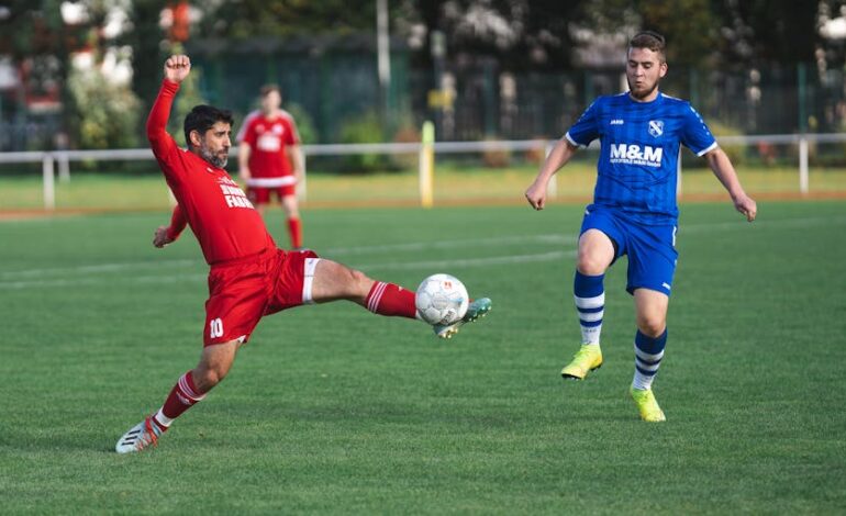 Players in vibrant uniforms compete in a dynamic soccer match outdoors.