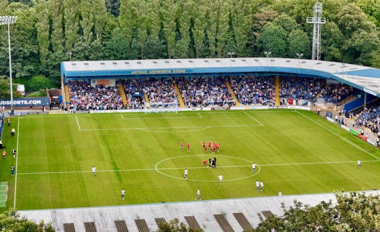 An aerial view of a football match in progress at Bury's Arthur Ashworth Stand.