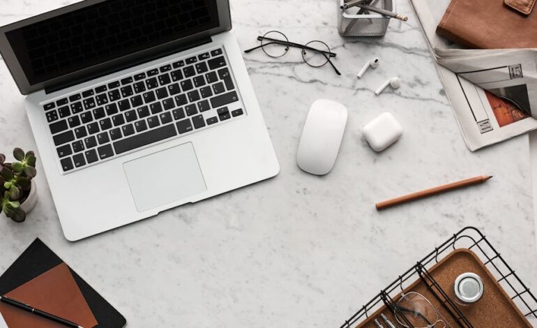 Discover a clean, organized workspace featuring a laptop, AirPods, and stationery essentials on a marble desk.
