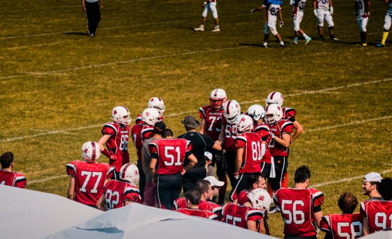 American football team huddling on field for strategy meeting during a game.
