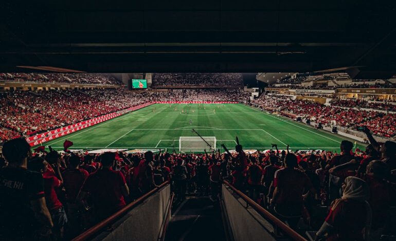 An exciting football match with passionate fans filling the stadium under bright lights, capturing sports energy.