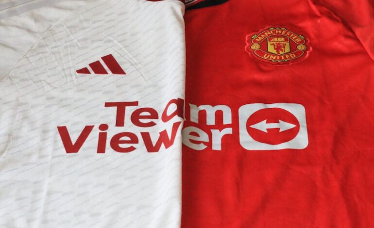 Close-up of Manchester United 2023 jerseys showcasing red and white designs.