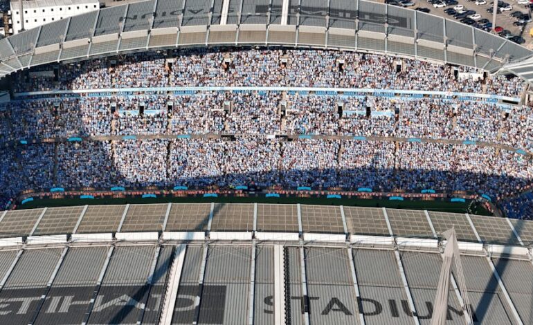 Aerial shot of Etihad Stadium filled with soccer fans in Manchester, UK.