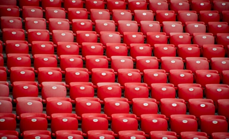 Empty red stadium seats in symmetrical arrangement at San Mames stadium in Bilbao, Spain.