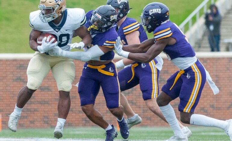 College football players in action on the field, showcasing teamwork and competition.