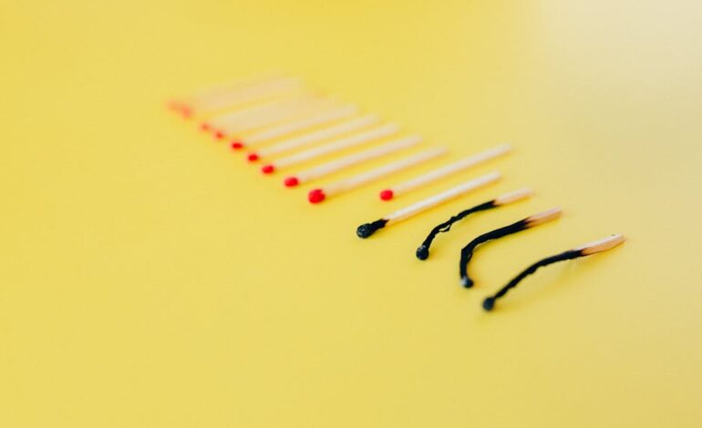 Symbolic representation of burnout using matches on a yellow background, illustrating exhaustion.