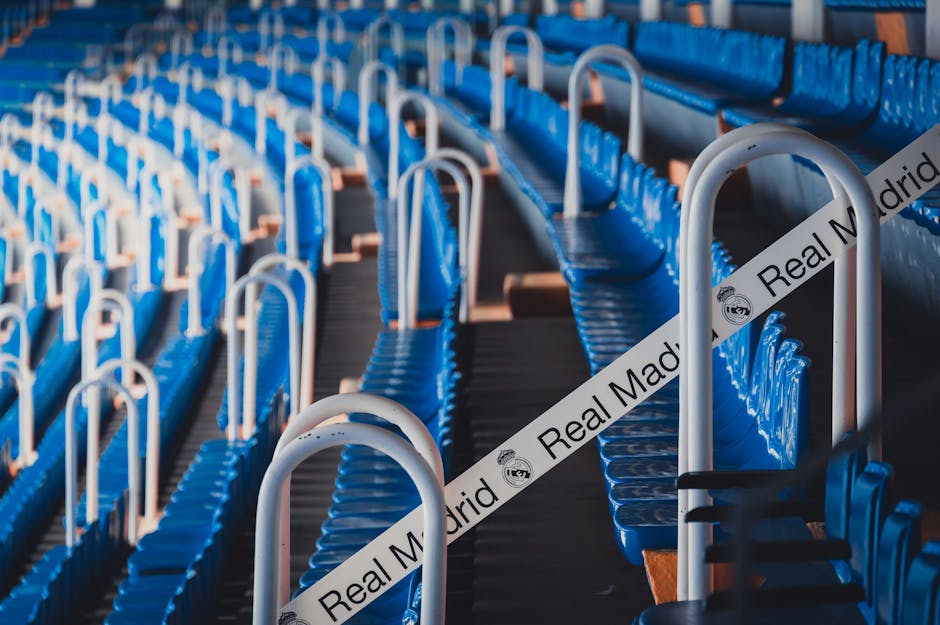 Rows of blue stadium seats in Madrid's iconic Bernabéu Stadium, featuring Real Madrid branding.