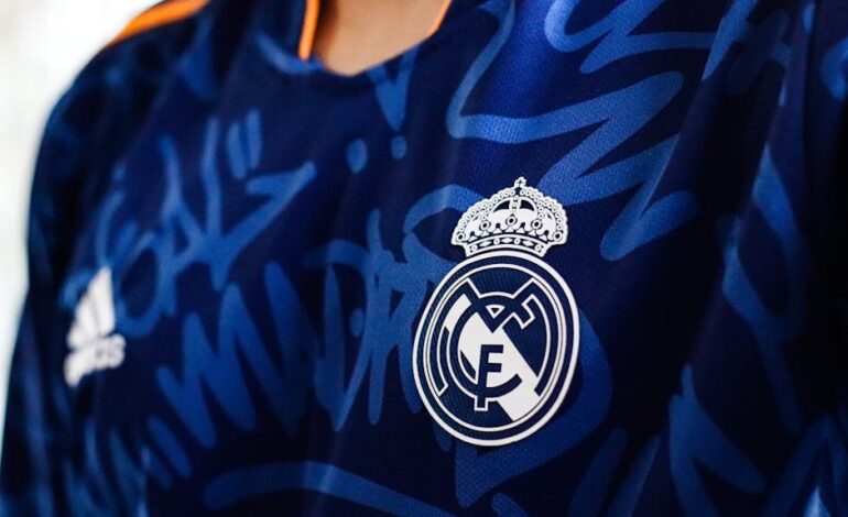 Detailed view of a blue soccer jersey featuring a prominent club emblem, ideal for sports branding.