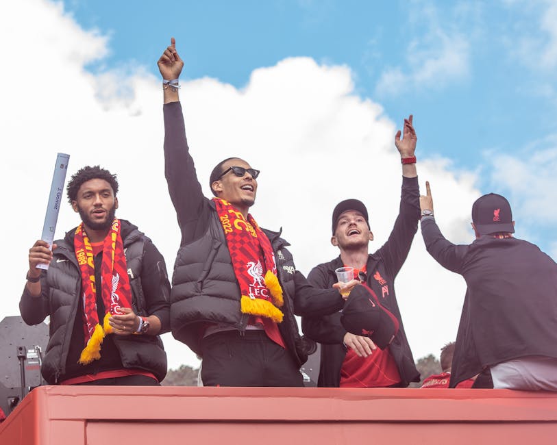 Fans celebrate with Liverpool FC players during a victory parade in Liverpool, England.