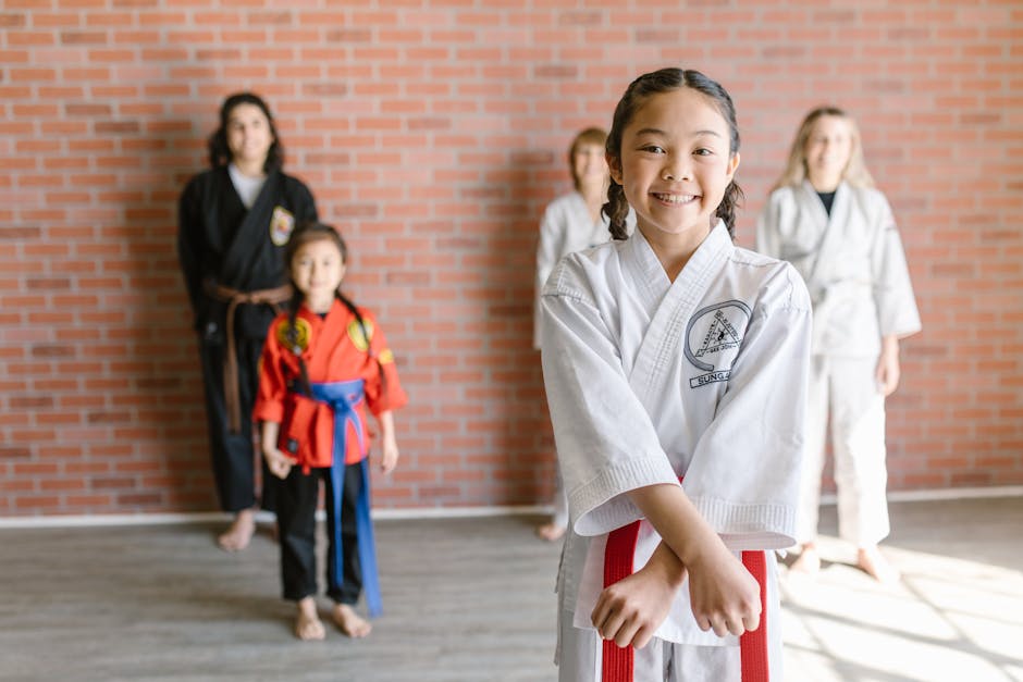 Young karate students in uniform practicing at the dojo with their instructor.