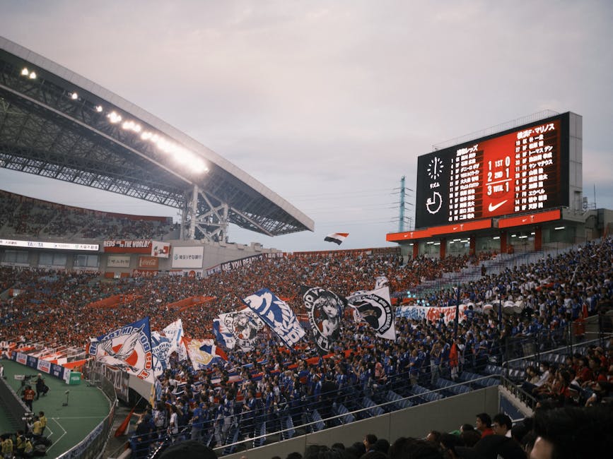 Energetic soccer match scene with cheering crowd and colorful flags in a large stadium.