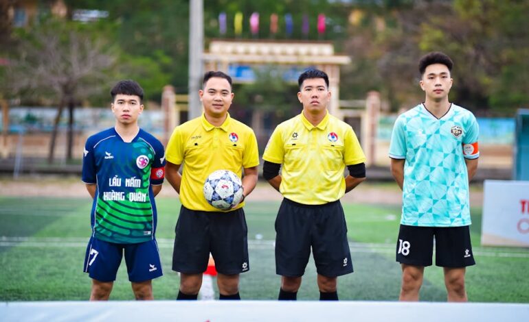 Football players and referees posing before a match in Hanoi, Vietnam.